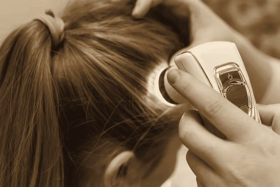 Exame do couro cabeludo com dermatoscópio em consulta de tricologia